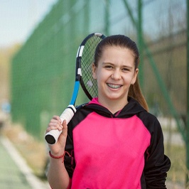 A young girl on a tennis court holding a racquet