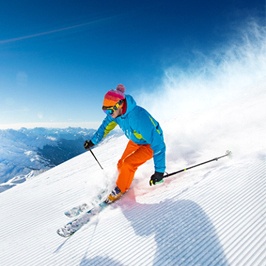 A person skiing down a mountain while the sun is shining
