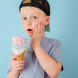 little boy having tooth sensitivity when eating ice cream