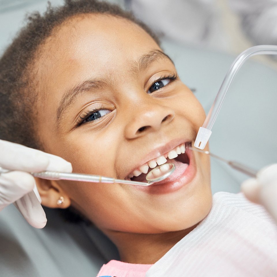 little girl smiling while she has her teeth examined