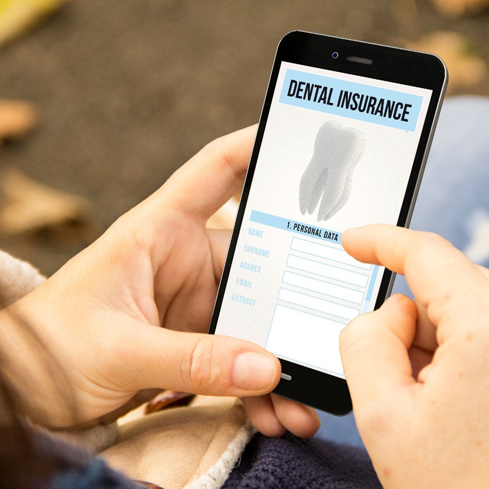 person scrolling through their phone and looking at dental insurance