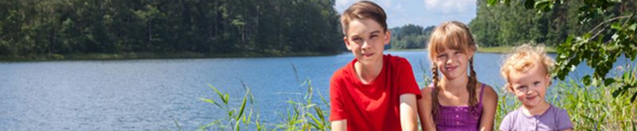 Children of different ages sitting by body of water