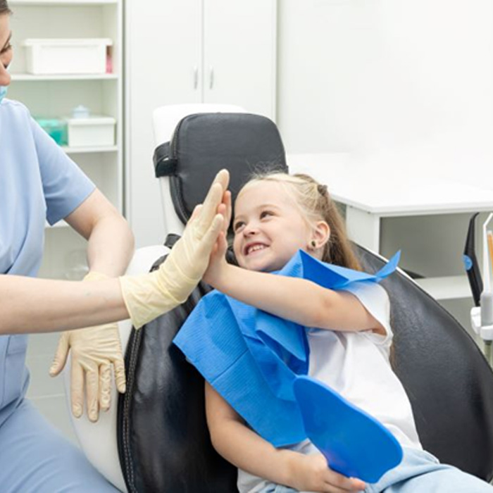 Pediatric dentist high-fiving patient