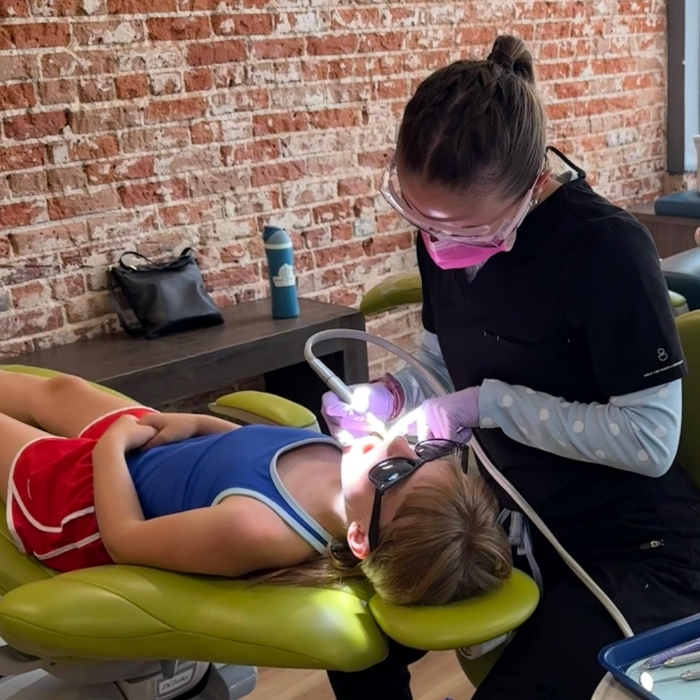 Pediatric dentist high-fiving patient