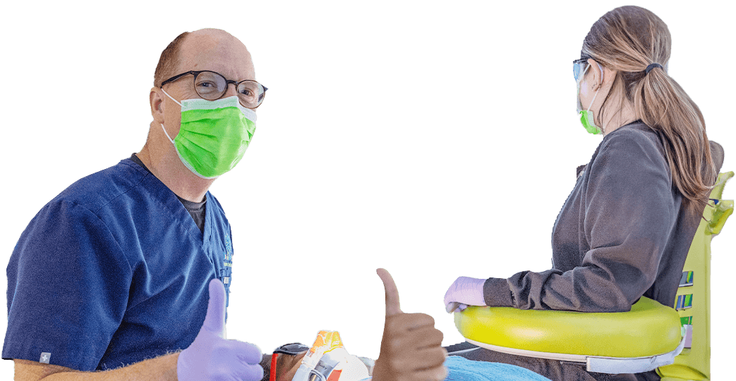 Pediatric dental team member helping mother and child at reception desk