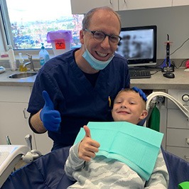 Dentist and child giving thumbs up