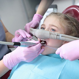 young girl with a nitrous oxide nasal mask on her face during dental work 