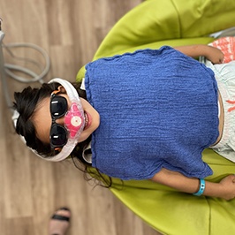 A young girl and her mother looking at her improved smile while visiting a sedation dentist for kids in Denver