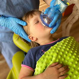 A young boy wearing a mask over his nose in preparation for receiving nitrous oxide