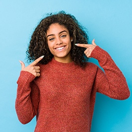 happy teen girl pointing to her smile
