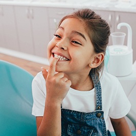 Happy girl pointing at teeth after getting filling