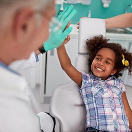Happy little girl giving high five to dentist