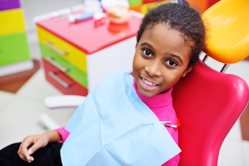 a little girl in the dentist’s chair smiling