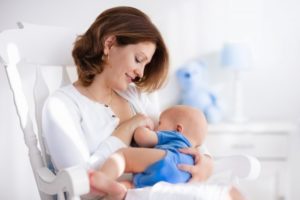 a mother nursing her baby while seated in a rocking chair