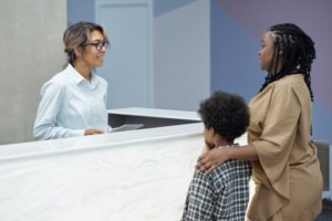 mom and child talking to a receptionist about dental insurance