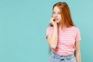 child with fingernails in their mouth