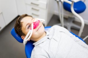 anxious kid getting nitrous oxide sedation in the dentist’s chair