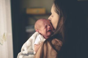 crying newborn in mom’s arms