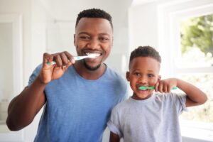 father and son brushing their teeth together