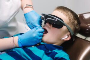 boy with headphones and glasses on for dental work